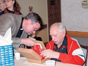 On his 100th birthday, Dillard Wilcox opens a gift from Concordia Theological Seminarian Robert Hauter.