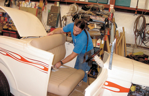 Marcus Marquart places the newly upholstered seat in a 1932 Ford Roadster.