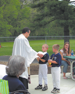 Grand Opening for “The Stand” was held on Friday, April 30th.  (L-R) Included in the Grand Opening was a Dedication, prayer, and blessing by Father Joe Rulli, along with alter boys Matt and Mick Palmer from St. Therese.