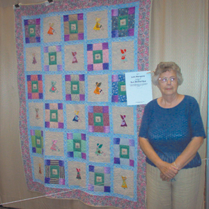 Lois Mangona stands next to her “Sunbonnet Sue” quilt in the Grand Wayne Center, during the Three Rivers Quilt Festival.