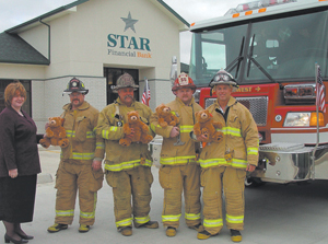 photo by Cindy Cornwell By donating a new or gently loved stuffed animal to Waynedale’s STAR Bank now through December 13, 2004, you can give a child a friend when they need it most.  The bears will be given to fire and police departments in the Waynedale area.  (L-R) STAR Branch Operations Officer Belinda Schroeder donates the first bears to Southwest Fire Department Firefighters Firefighter Bernie Noll, Assistant Chief Kim Lenwell, Captain Doug Peters, and Chief Don Patnoude.  The Southwest Allen County Fire Protection District in the Waynedale area is located on Old Trail Road and Indianapolis Road.