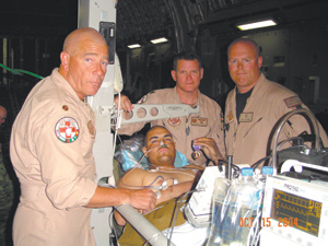 (L-R) Major David Cox, Lt. Col. Jerry Fenwick, SSgt. Eric Rine, with Joey Rodriguez in the middle with his Purple Heart, transported from Kandahar, Afghanistan to Landsthul, Germany via C-17 aircraft.