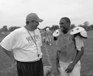 Head Coach Larry Getts talks to running back Sophomore Ray Byers on a hot Friday afternoon at the Wayne High School practice field.