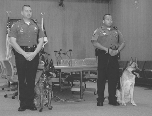 The Fort Wayne Police Department’s 13-week Basic K-9 Training Program graduated two officers and their K-9 partners on Friday, October 21, 2005. Those graduating included Officer John Drummer/K-9 Partner Kelly and Officer Thomas Andrews/K-9 Partner Nimo. K-9 Kelly is the first female police service dog in the city’s history. (Right) FWPD K-9 Trainer Officer Kevin Weber observes the swearing-in ceremony.