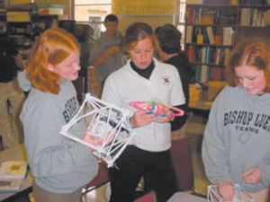 Kelli Cyr, Annette Wellman, and Lindsey VanDyck compare projects during the Great Egg Drop at Bishop Luers’ High School physics class.