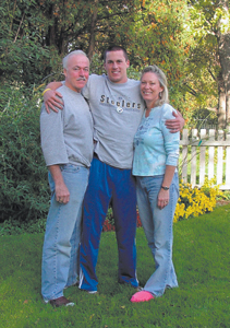 With a Blue Star Banner Flag proudly displayed in their home, Tony Moore relaxes with mom and dad during his brief stay back home on Indiana Avenue, Thursday, November 3, 2005.