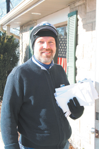 Dave Winn, local Waynedale carrier, brings checks into The Waynedale News on Friday, December 8. 