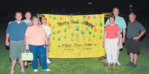 Pamela and Eric Lehman (far right) pose with supporters next to the “Unity Hands of HOPE” banner at the American Cancer Society Relay For Life of South Central Allen County. 