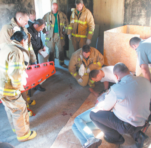 photo by Susan Banta Tony responds to an “unknown medical condition” call for a patient on the 4th floor of a building.  Tony, kneeling in the center, 4th from right, listens as the patient provides answers to questions in this emergency simulation.