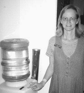 Lois poses by the water cooler she donated to the Marie Webster House renovation project.