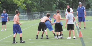It was a sweltering 90 degrees all three days during the Kevin Donley Football Camp held at the University of St. Francis. Leading the next generation in the right direction, Assistant Coach Patrick Donley (L) and Assistant Coach Trevor Miller (R) keep players on task while having fun with “Cougar Ball.”