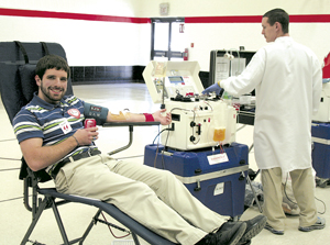 Honoring a tradition of giving blood since he was a junior in high school, Daniel Davis was a double red blood cell donator. Shaun, with the American Red Cross, monitors the Haemonetics machine during the procedure.