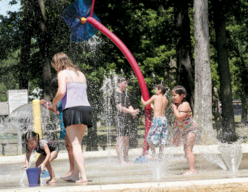 Making a big splash and cooling off is Rachel Aguilar and children Natalie, Connor, Dawson and Katelyn. Temperatures reached a high of 90 degrees at the newly remodeled Splash Pad in the Waynedale Park.