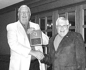 Jim Lambert receiving a plaque for “South Side Optimist of the Year” award from past President Joe Crozier.