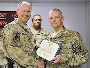 Lt. Col. Garry B. Bush (right), commander of the Army Field Support Battalion - Kandahar, presents Staff Sgt. John R. Bice (left) with an Army Commendation Medal for being named “The Sabre Non-commissioned Officer of the Quarter.”