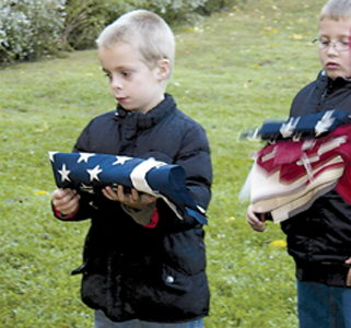 L-R Cub Scouts Kendrick Marcum and Alexander Edwards prepare for retiring their flags. 