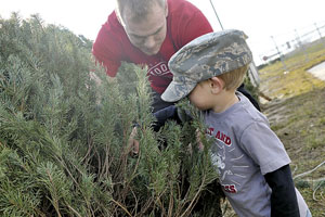 122nd Fighter Wing recruit Michael Streeter and son Abraham inspect Christmas trees for sale at the 122nd Fighter Wing’s Historical Air Park, Baer Field Heritage Park.