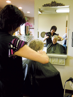 Co-owner Kathy Freiburger styles customer Helen Muntzinger’s hair at the Hair Affair Spring Social.