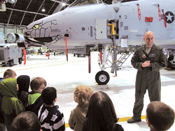 Major Brad Reynolds talks to the preschoolers in front of the A-10 fighter jet.