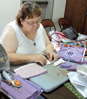 Marty Rust diligently at work on a star design prairie point potholder.