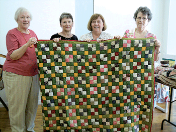 Bonnie Pilditch, Marty Smith, Barb Greer, and Deb Neuenschwander and the Greer Family quilt made by Mary Wilkes Bass circa 1870-1890.
