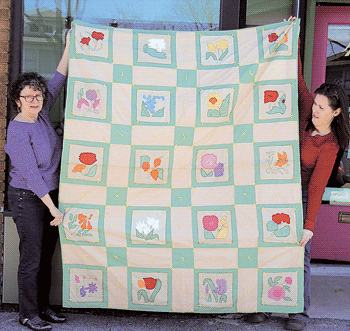 Darlene Gerster and Joellen Child with the appliqué floral comforter created by  Darlene’s Great-aunt Cordelia Caroline Stohlman.