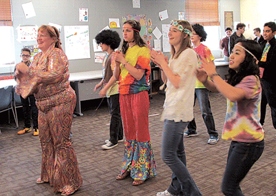 Teacher Mrs. Anita Senesac and Saint Elizabeth Ann Seton Catholic School students learn dance steps from the 1970s.