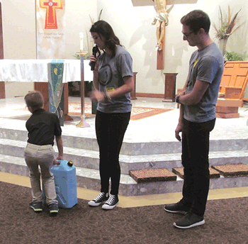 Saint Elizabeth Ann Seton Catholic School third grader Matthew McAllister tries to pick up a 44 lb. water jerry can.